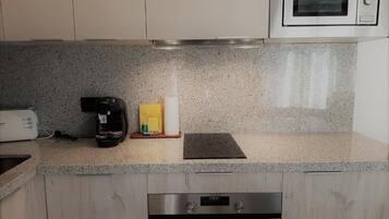 A kitchen with granite countertops, a coffee maker, a toaster, and a microwave.