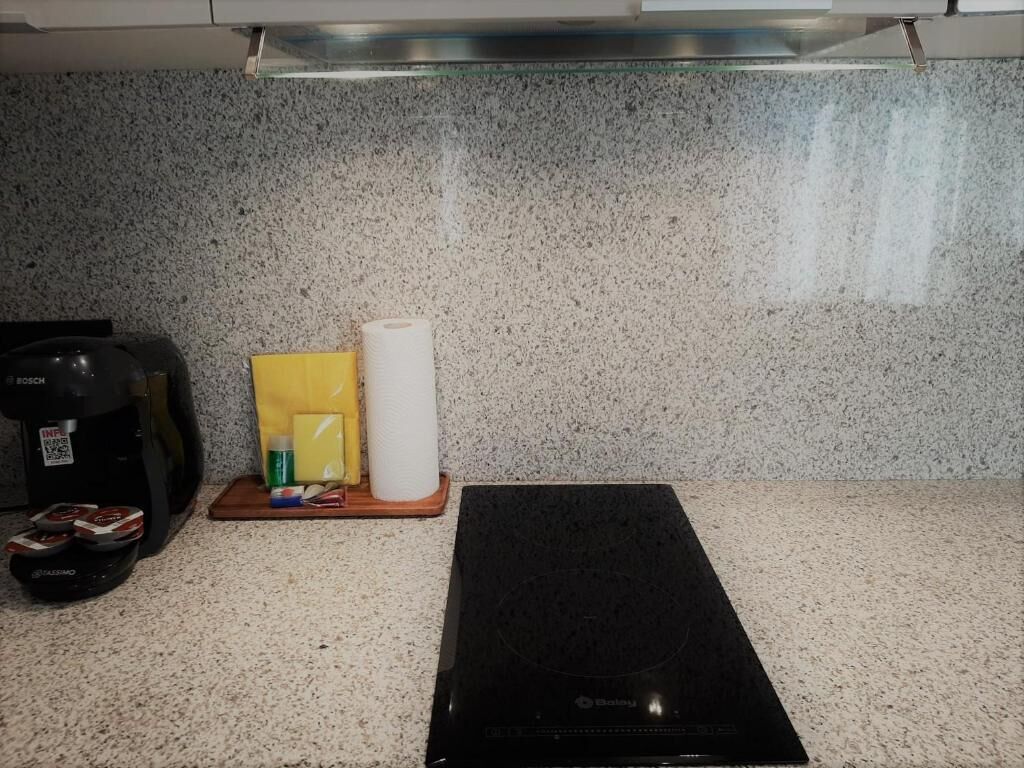 A kitchen counter with a Bosch induction cooktop, a coffee maker, a roll of paper towels, and a yellow box.