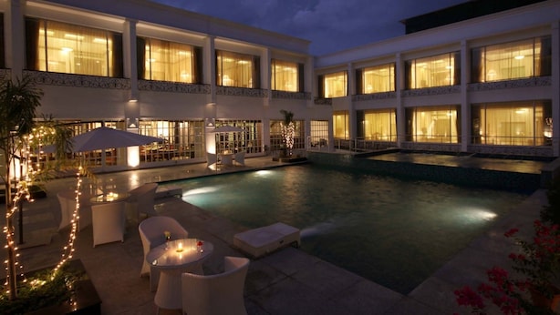 Un hotel con piscina, area salotto all'aperto e ampie finestre.