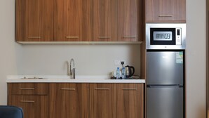 Una cocina moderna con armarios de madera, un refrigerador de acero inoxidable y un microondas.