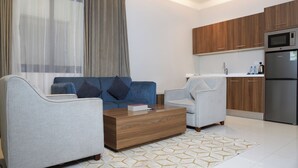 Una sala de estar moderna con un sofá, sillones y una mesa de centro.
