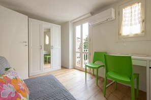 Une chambre à coucher avec un lit, un bureau, une chaise et une armoire.