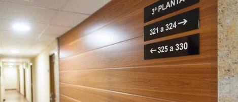 Un pasillo con señalización que indica los números de habitación de 321 a 324 y de 325 a 330.