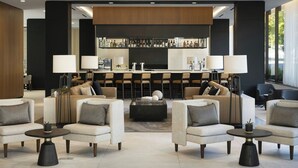 A modern lobby with sofas, a bar area, and a coffee table. - AC Hotel San Rafael Downtown (San Rafael)