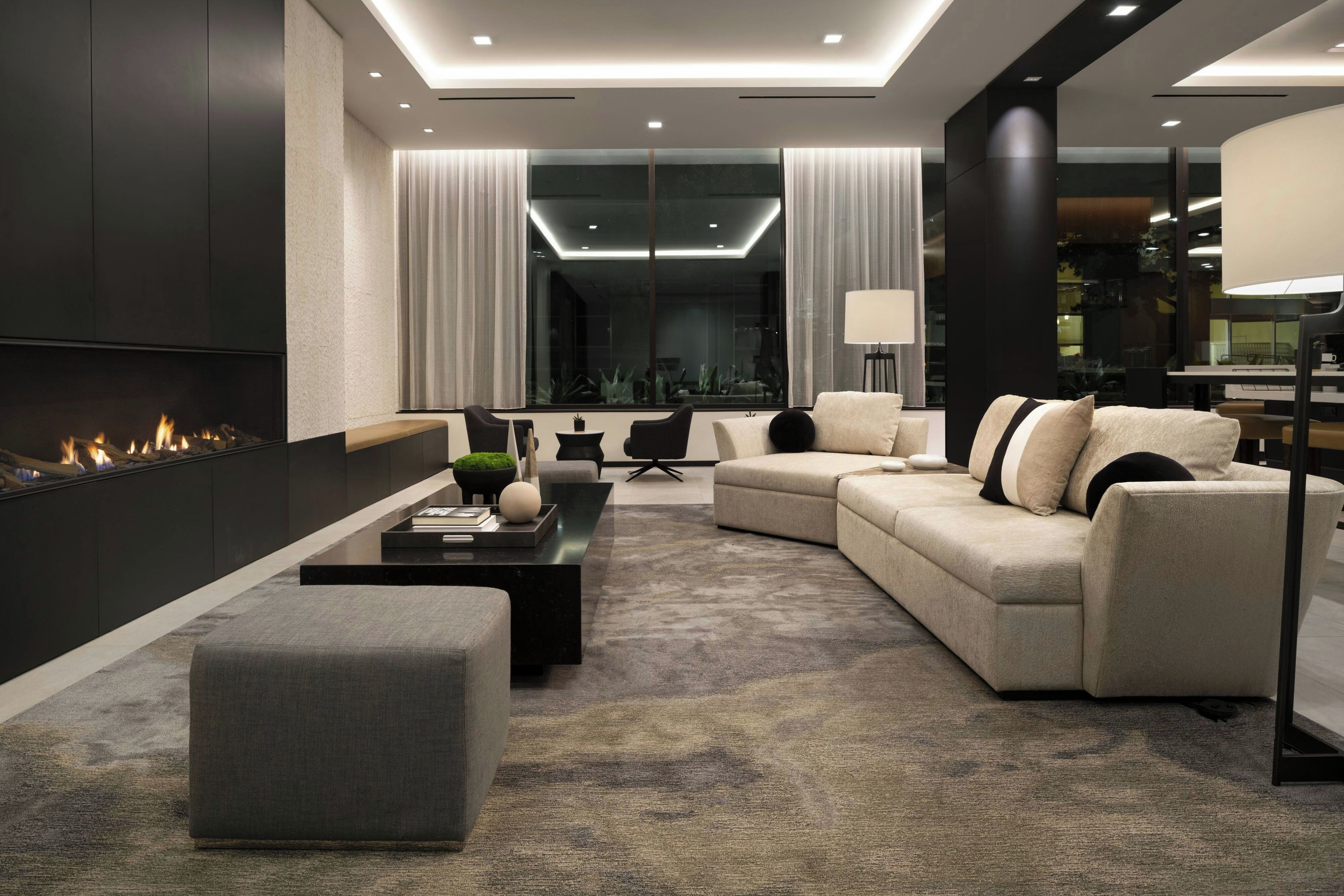 Un salon moderne avec un canapé d’angle, une table basse et une cheminée.