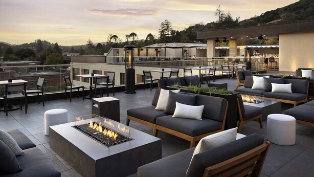 A rooftop terrace with outdoor seating, a fire pit, and a view of the surrounding landscape. - AC Hotel San Rafael Downtown (San Rafael)