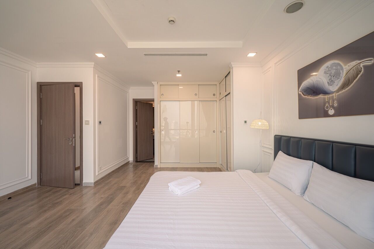Habitación de hotel con una cama grande, un armario, una puerta y una obra de arte colgada en la pared.