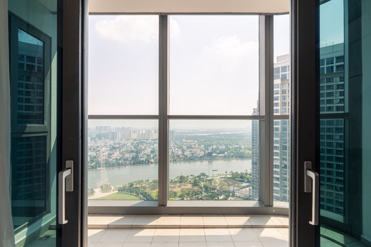 A large window with a view of a cityscape and a river.