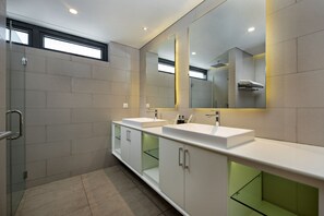 A modern bathroom with two sinks, a large mirror, and a glass shower enclosure. - The Point Villa Da Nang (Da Nang)