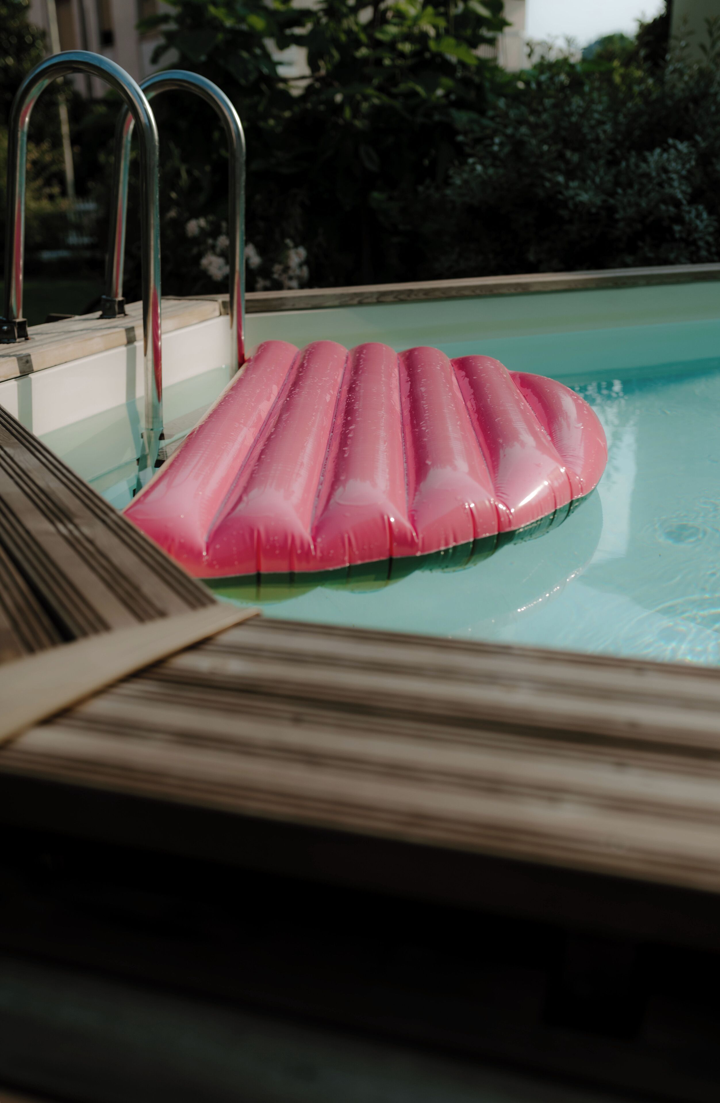 A swimming pool with a pink inflatable float.