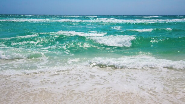 Una playa con olas y agua cristalina.