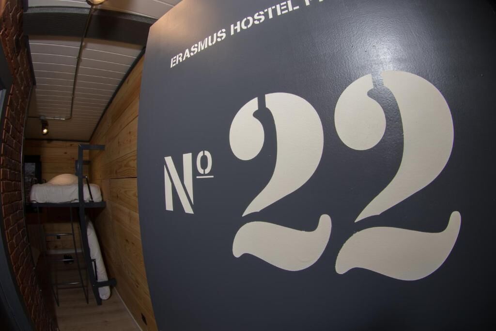 Interior de un albergue con literas y un cartel grande con el número 22.