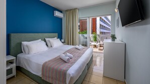 Een hotelkamer met een bed, een televisie, een nachtkastje en uitzicht.