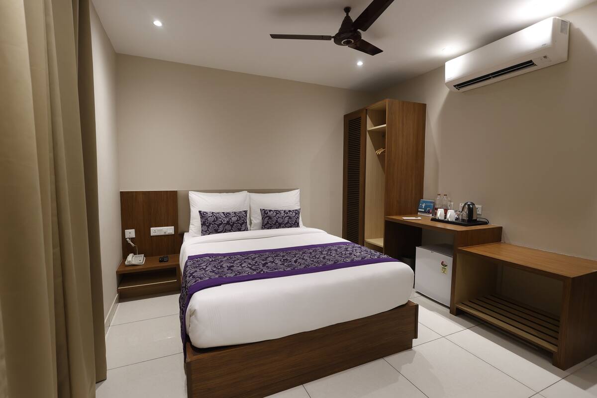 Une chambre d’hôtel moderne, dotée d’un grand lit, d’un bureau et d’une armoire.