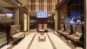 A lobby with a marble floor, a central coffee table, and four sofas arranged around it. - Pride Biznotel Canopus Digha (Kanthi)