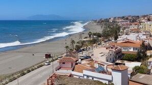 Un pueblo costero con playa, edificios y una carretera.