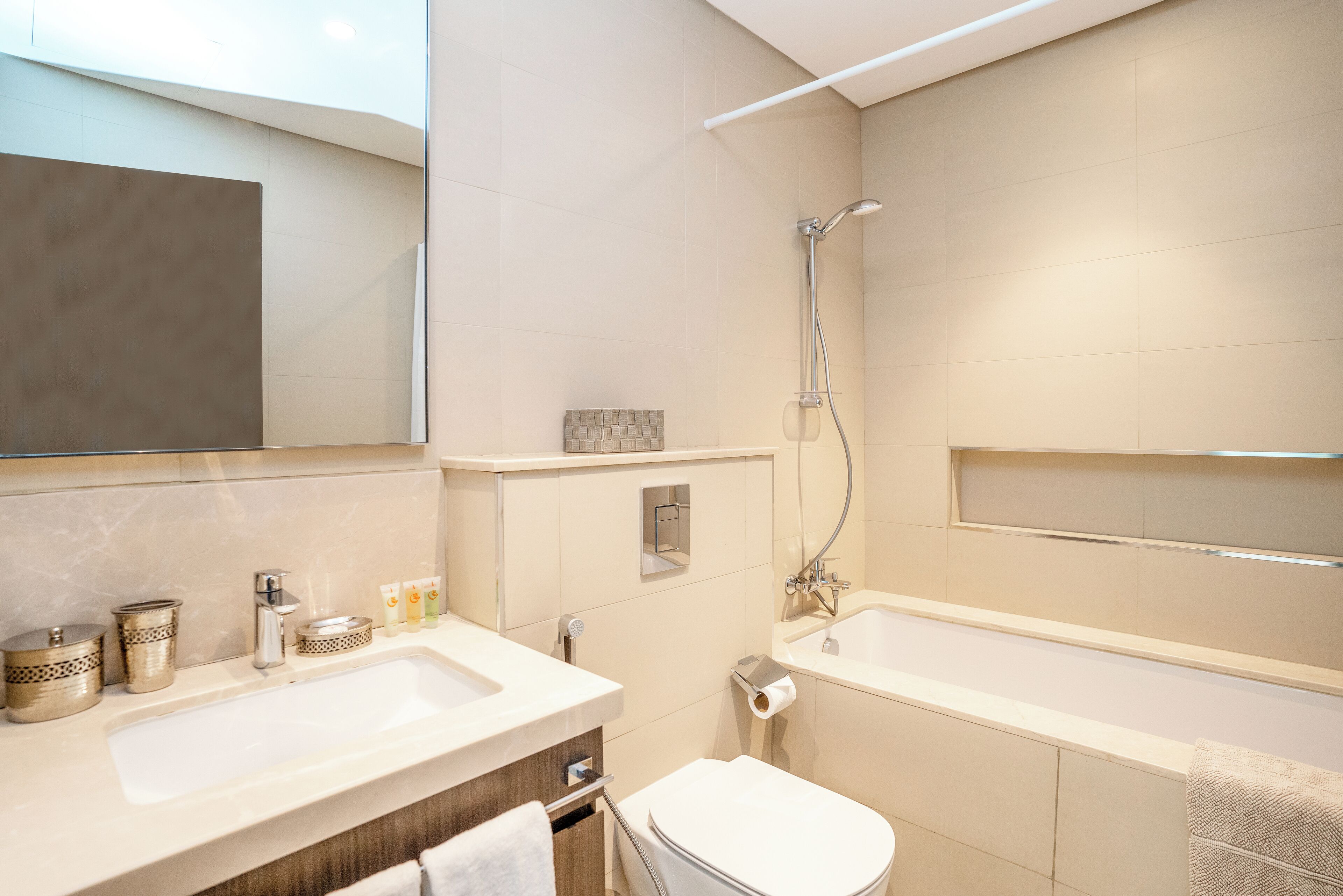 Et moderne badeværelse med stor vask, toilet og badekar.
