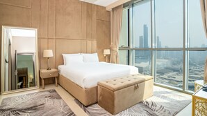 Quarto de hotel moderno com uma cama grande, área de estar, janela ampla com vista para a cidade e espelho com porta.