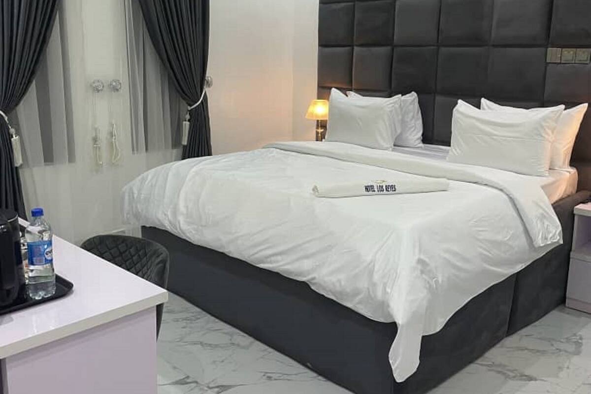 Een moderne hotelkamer met een groot bed, een bureau en een douche.