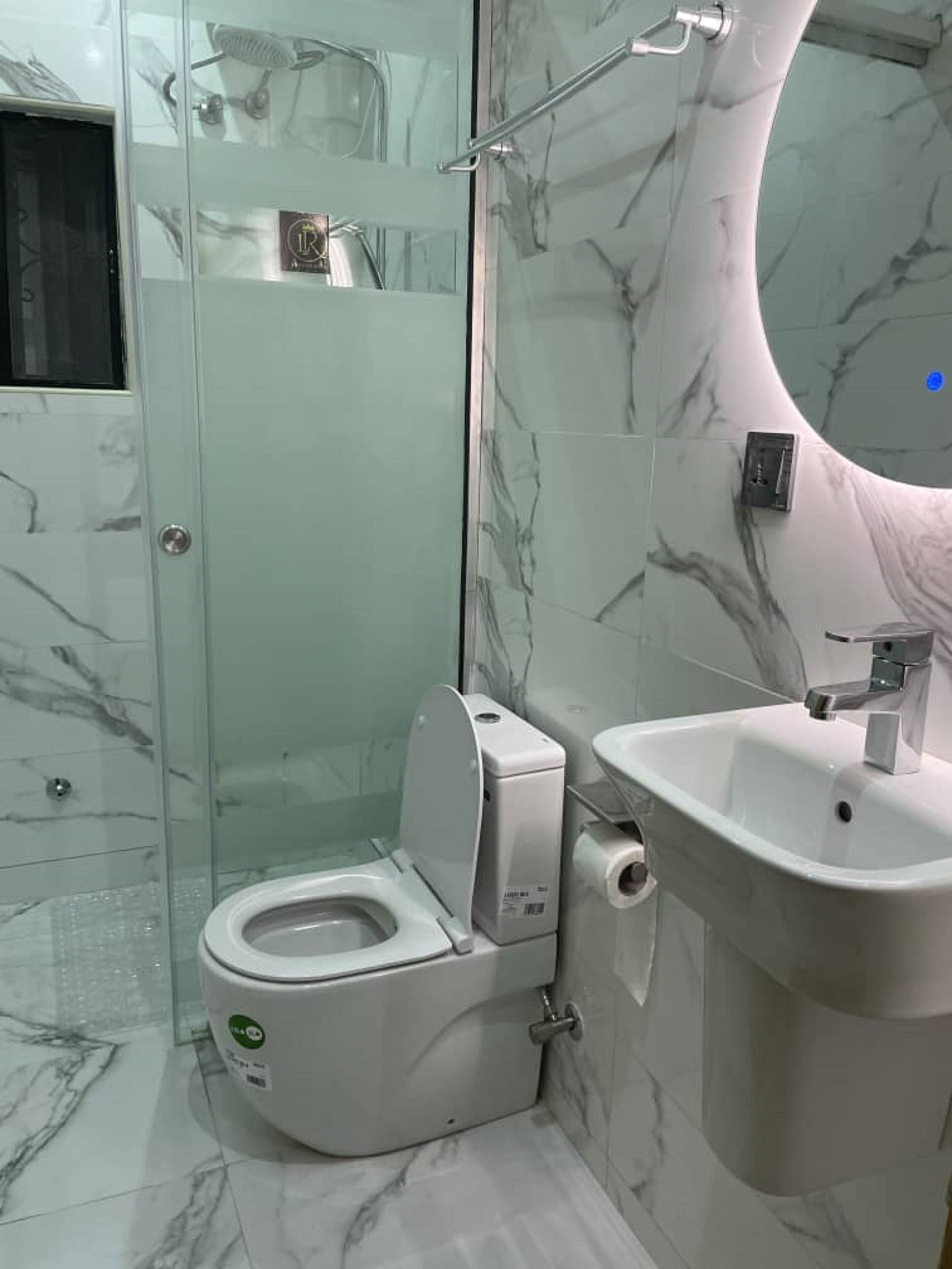 Ein modernes Badezimmer mit Toilette, Waschbecken und Duschkabine aus Glas.