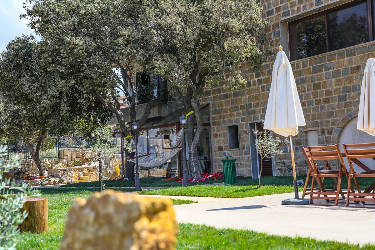 A stone building with outdoor seating and a hammock.