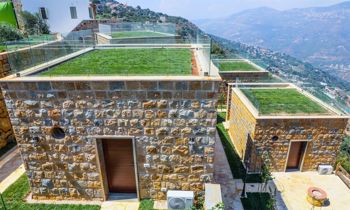 Un edificio in pietra con tetto piatto, una porta e un condizionatore d'aria.