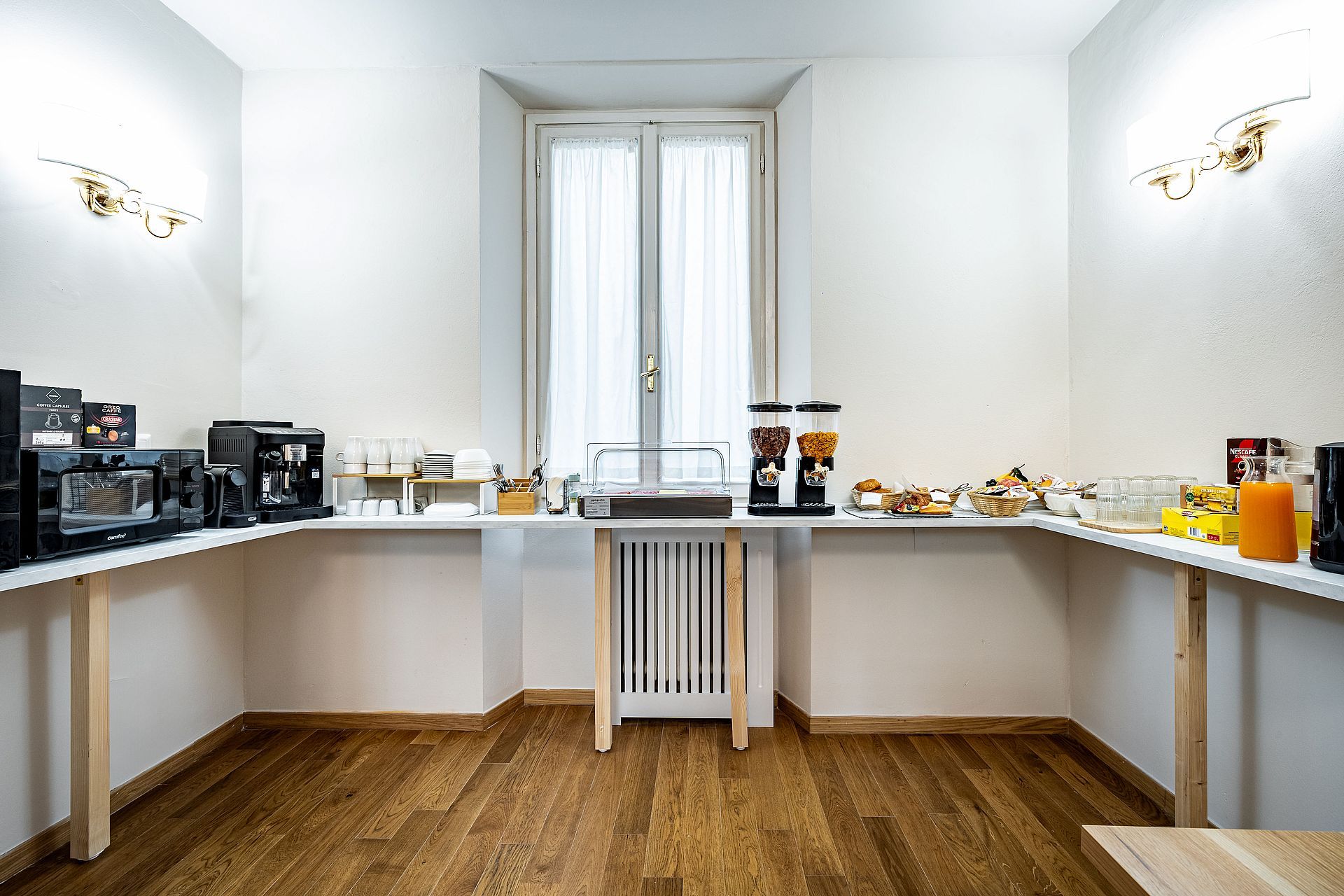 A compact kitchen with a central island, equipped with a coffee machine, a kettle, and a toaster.