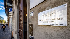 A building with a sign for Maison Pitti Florence, indicating rooms and suites available. - Maison Pitti Florence (Florence)