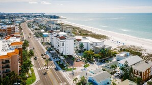 Un paysage urbain côtier avec une plage, des bâtiments et une route.