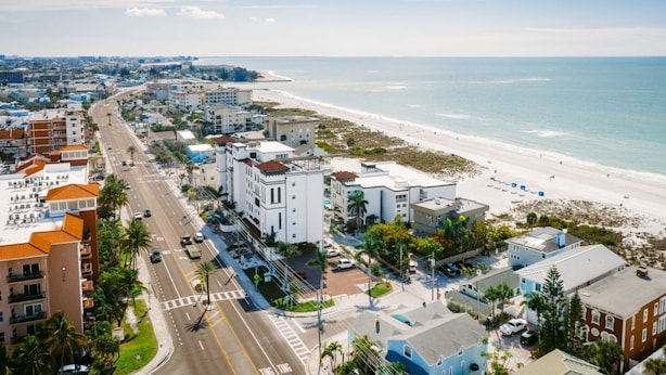 Eine Küstenstadt mit Strand, Gebäuden und einer Straße.