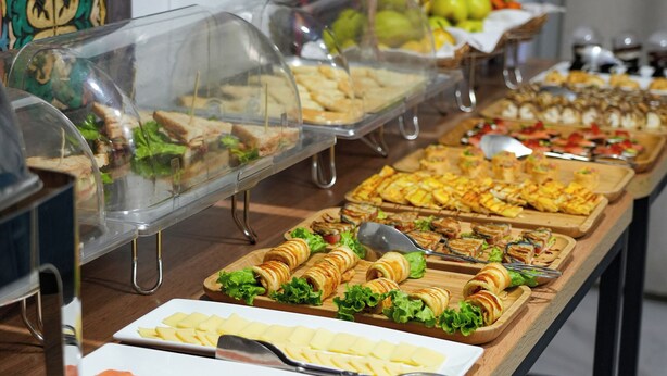 A buffet with various food items including sandwiches, salads, and sliced meats. - Aisha Hotel (Bishkek)
