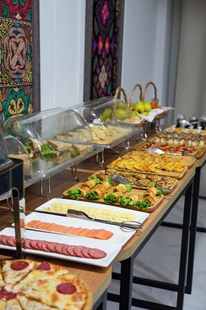 A buffet with various food items including sandwiches, salads, and sliced meats. - Aisha Hotel (Bishkek)