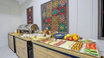 A buffet setup with various food items and a coffee machine.