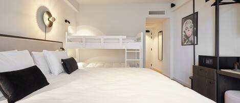 Una habitación de hotel moderna con una litera, un escritorio y un armario.