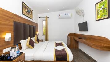Una habitación de hotel con una cama, una mesita de noche y un televisor en la pared.