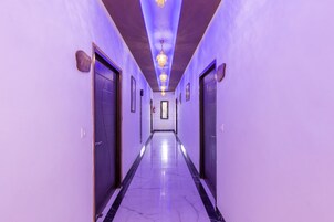 A hallway with a marble floor and purple lighting.