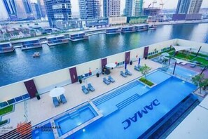 Un espace piscine équipé de chaises longues et une piscine portant l’inscription « JAC ».