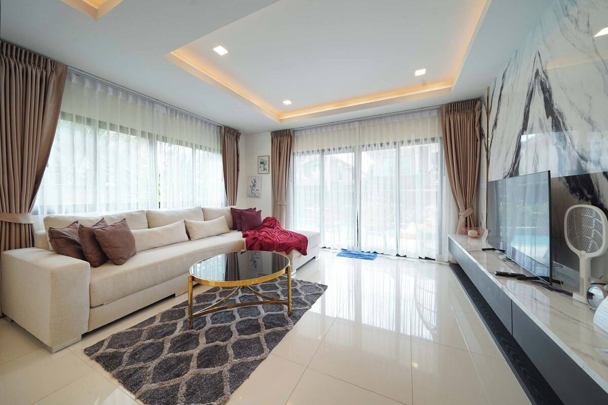 Una sala de estar moderna con un sofá, una mesa de centro y un televisor.