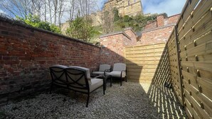 Un patio con mobiliario exterior y vista a un edificio histórico.