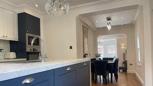 Una cocina moderna con armarios azul oscuro, encimera blanca y una isla central.