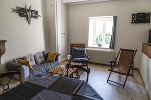 A cozy living room with a sofa, two chairs, a coffee table, and a window with a view.
