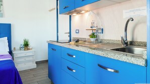 Une cuisine moderne avec des meubles bleus, un plan de travail en granit et un évier en acier inoxydable.