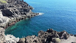 Un paysage côtier caractérisé par un terrain rocheux et des eaux d’un bleu limpide.