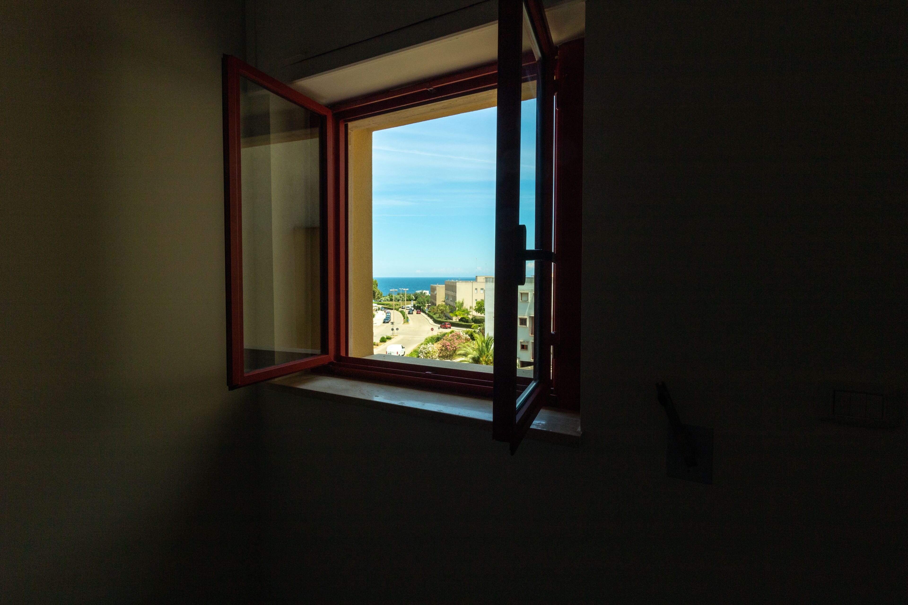Una habitación con ventana que da a una zona residencial.