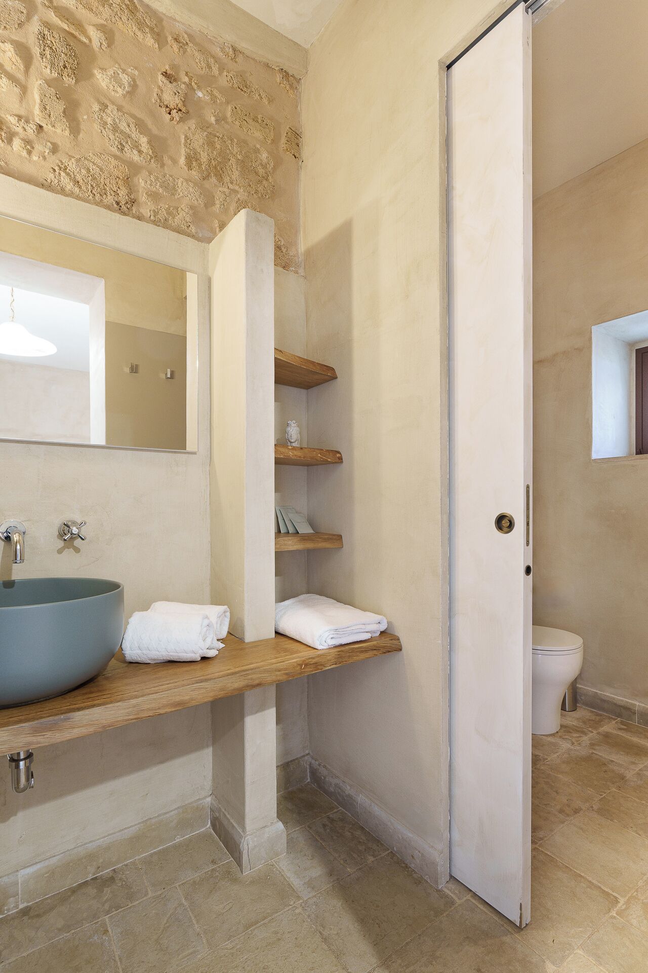 Un bagno con un lavandino grande, uno specchio, una doccia e un water.