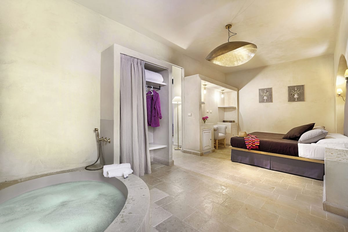 Uma casa de banho moderna com banheira, chuveiro e um closet espaçoso com cabides.