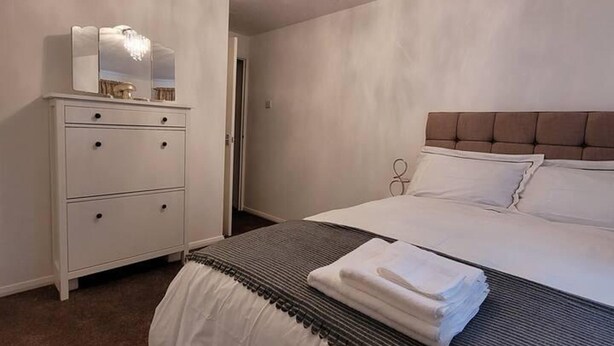 A bedroom with a bed, a dresser, and a mirror. - Tastefully Decorated 1 bed Flat Near Abbeywood (Belvedere)