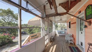 A covered porch with wooden flooring, white railings, and a view of the surrounding area. - Latitude Adjustment - Ocracoke Island (Ocracoke)