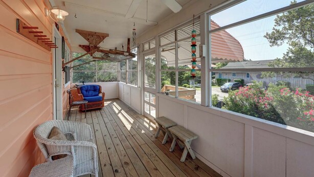 A covered porch with a ceiling fan, wicker furniture, and a view of the neighborhood. - Latitude Adjustment - Ocracoke Island (Ocracoke)