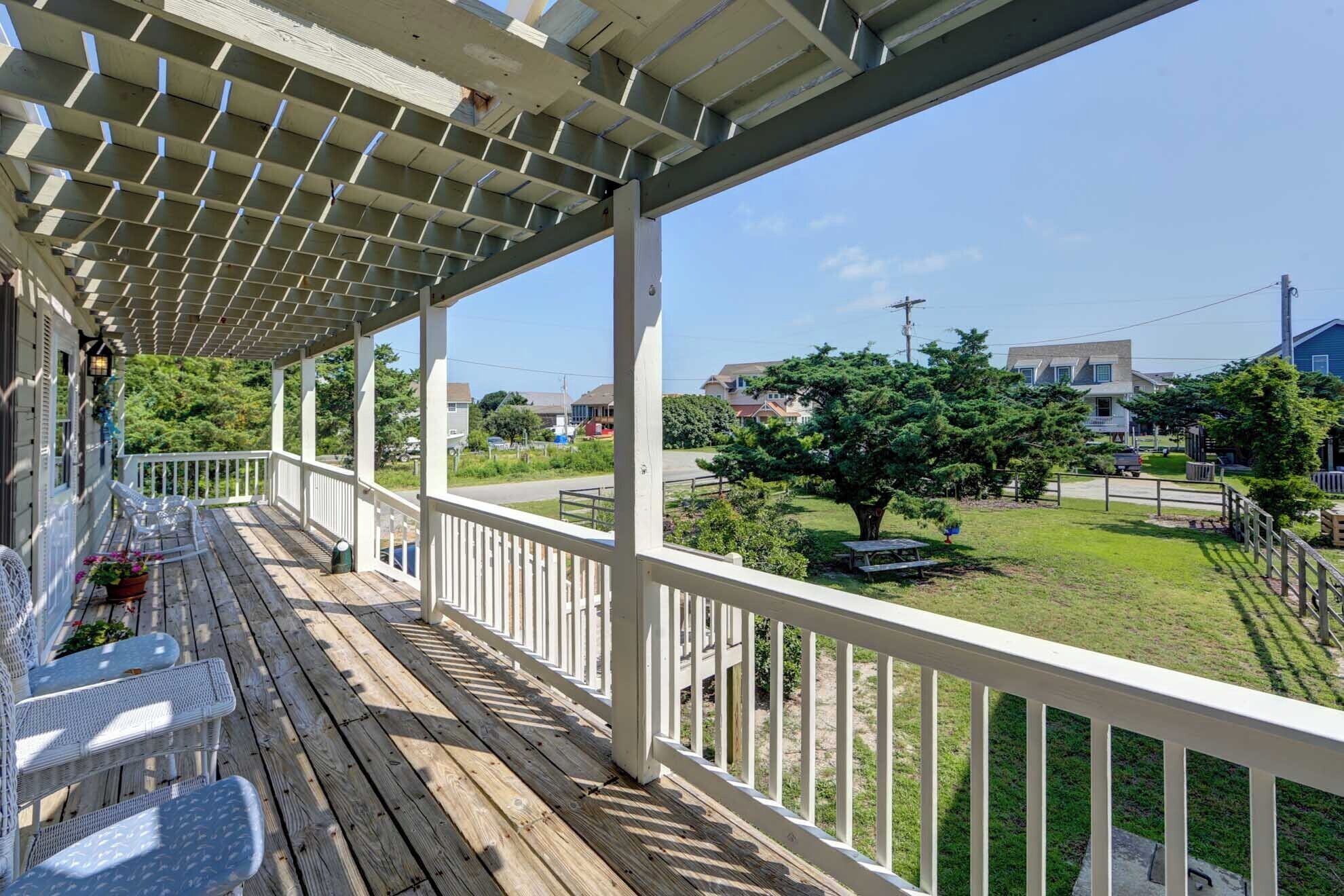 A covered porch with a view of a residential neighborhood.